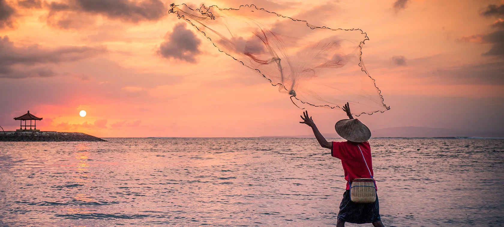 As the sun starts to set on another fabulous day in Bali... along the coast you'll see fishermen casting their nets or heading out in boats. They'll return after dawn to sell their fresh catches to market traders waiting on the shores.